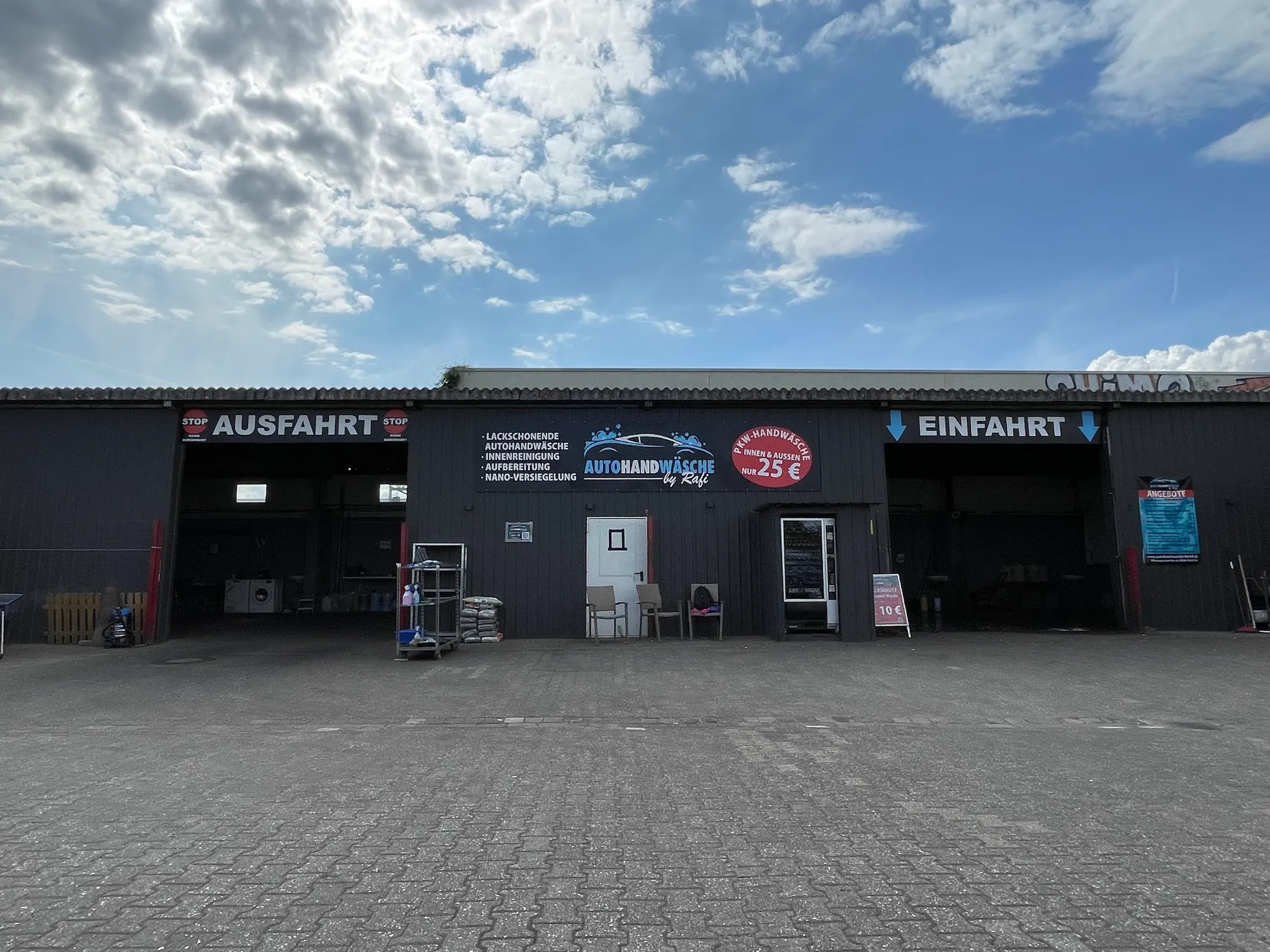 Die Waschhalle mit Einfahrt und Ausfahrt unter blauem Himmel