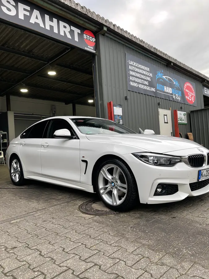 Frisch gewaschener weißer BMW vor der Ausfahrt der Waschhalle