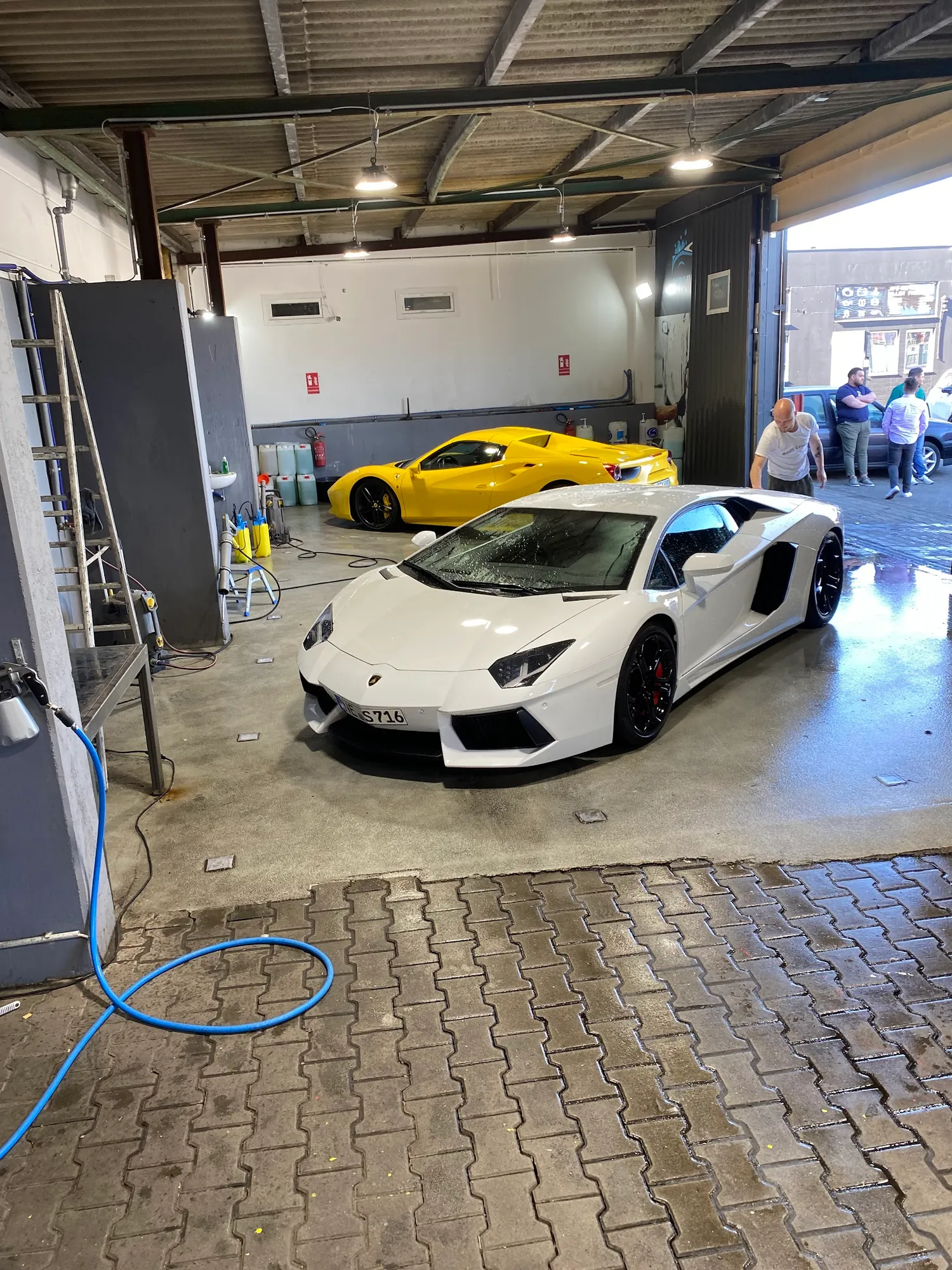 Weißer Lamborghini in der Waschhalle auf nassem Boden